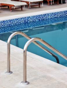 una piscina con corrimano di metallo accanto a una piscina di Golden Beach Suites a Sarandë Altre 47 foto