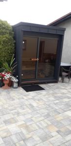 czarny budynek z przeszklonymi drzwiami na patio w obiekcie Apartmán Woodcock w mieście Poniklá