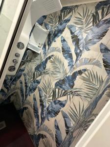 un bagno con carta da parati blu e bianca con piante di principessa la vigna a Catania Altre 27 foto