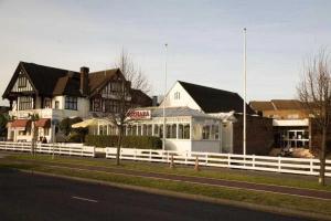 アイルワースにあるOsterley Park Group Ltd Osterley Park Hotelの通りの横に白柵のある家