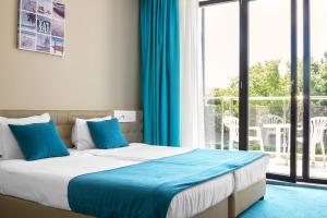 a bedroom with a bed and a large window at Arena Mar Hotel and SPA in Golden Sands