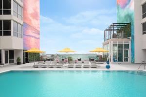 a swimming pool with chairs and umbrellas on a building at Residence Inn by Marriott Clearwater Beach in Clearwater Beach