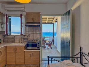 a kitchen with a view of the ocean at Niriides Studios & Apartments in Kithnos