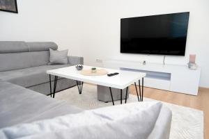 a living room with a white table and a tv at Apartman Astral in Jajce