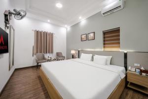 a bedroom with a large white bed and a desk at A25 Hotel - 185-187 Lò Đúc in Hanoi +45 photos