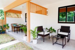a patio with chairs and tables and plants at Ysabelle's Inn in El Nido