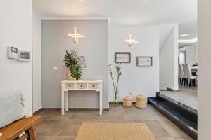 a living room with a table and crosses on the wall at Villa Camelia by Homie in Santo António