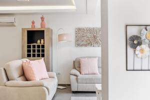 a living room with two chairs and a couch at Villa Camelia by Homie in Santo António