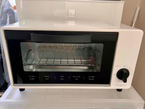 a white toaster oven with a rack inside at Minpaku Hasegawa A in Numata