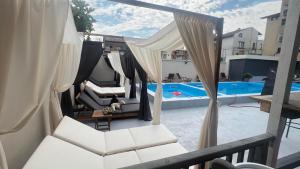 a balcony with white chairs and a swimming pool at Family Hotel Malibu in Chernomorets