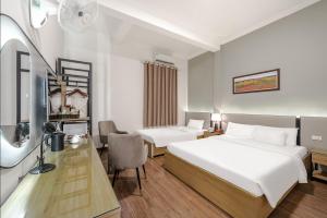 a hotel room with two beds and a desk at A25 Hotel - 185-187 Lò Đúc in Hanoi