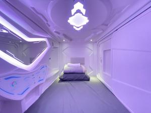 a purple room with a bed and a ceiling at U Capsule Hotel Kulai in Kulai