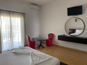 a bedroom with a bed and a mirror and a table at Hotel Velipoja Park in Velipojë
