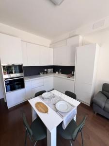 ボローニャにあるPanigale Deluxe Apartmentの白いテーブルと椅子のある白いキッチン