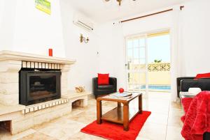 a living room with a fireplace and a red rug at Villa Puerto Rico by Algarve Vacation in Albufeira +16 photos