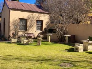 a house with a yard with a bench in front of it at Cherry Lane Guest House in Ficksburg