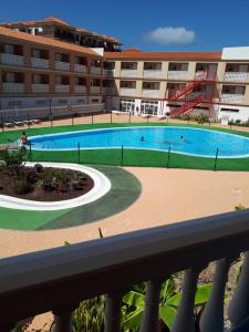a large swimming pool in front of a building at Chill Out Tenerife Sud - monolocale con piscina riscaldata in Costa Del Silencio