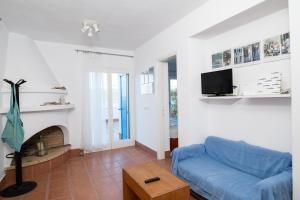 a living room with a blue couch and a fireplace at Elea Villas Steni Vala Alonissos in Steni Vala Alonissos