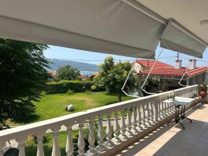 a white railing on a balcony with a view of a yard at Villa George in Paleros