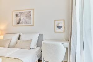 a white bedroom with a bed and a table at Ludwiga - Vierstädte Nest in Bietigheim-Bissingen