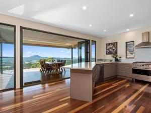 a kitchen with a view of a table and a dining room at Wilderness House in Kulangoor