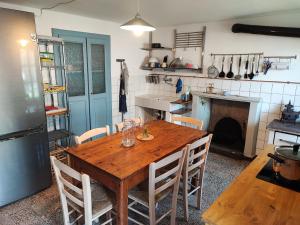 a kitchen with a wooden table with chairs and a fireplace at Casa Celestina in Cicogna
