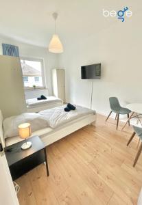 een slaapkamer met twee bedden en een tafel en stoelen bij BEGE APARTMENTS WorkStay Lodge in Essen