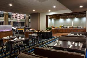 a dining room with tables and chairs and a restaurant at DoubleTree by Hilton Newark-Fremont in Newark