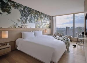 a bedroom with a large white bed and a large window at EAST Beijing in Beijing