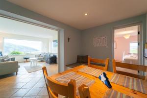a dining room with a table and a living room at Kilmurry Cottage - Superb Views in Kilmurry
