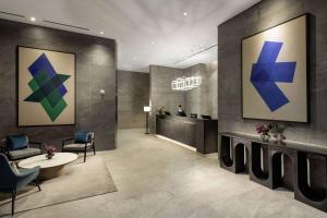 ソンナムにあるDoubleTree By Hilton Seoul Pangyo Residencesの青と緑の絵画が飾られた待合室のあるロビー