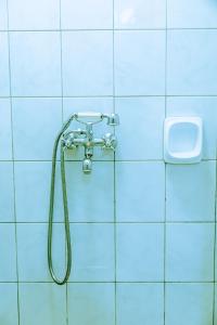 a shower in a bathroom with blue tiles at Castle Apartments Kampala 2 in Kampala +16 photos