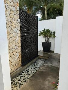 Una valla con un muro de piedra y una planta en maceta. en Residence Bel été, en Trou aux Biches 3 fotos más
