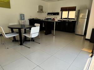 Una cocina con mesa y sillas y un refrigerador. en Residence Bel été, en Trou aux Biches