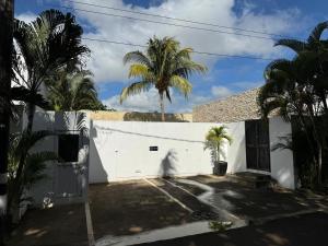una casa blanca con palmeras delante en Residence Bel été, en Trou aux Biches