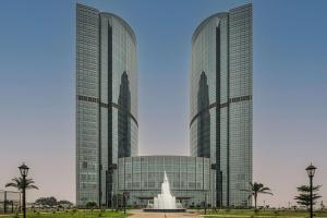 dos edificios altos con una fuente frente a ellos en Hilton Brazzaville Les Tours Jumelles Hotel & Residences, en Brazzaville