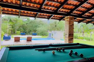 a pool table with balls on it in a backyard at Recanto Vultuoso Paraíso na Estrada Bonita com piscina aquecida Hidro Quadra de areia e Area de lazer completa in Joinville