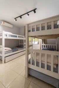 a room with three bunk beds in a room at Recanto Vultuoso Paraíso na Estrada Bonita com piscina aquecida Hidro Quadra de areia e Area de lazer completa in Joinville