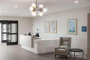 an office with a reception desk and a chair at WaterWalk Extended Stay by Wyndham Jacksonville Deerwood Pk in Jacksonville