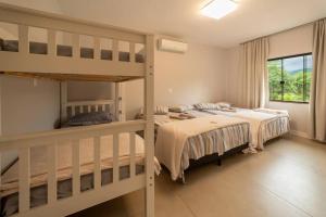 a bedroom with two bunk beds and a window at Recanto Vultuoso Paraíso na Estrada Bonita com piscina aquecida Hidro Quadra de areia e Area de lazer completa in Joinville +43 photos