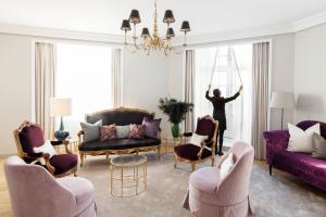 a woman is standing in a living room at Grand Hotel Oslo in Oslo