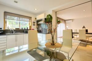 eine Küche mit Glastisch und weißen Schränken in der Unterkunft Casa Dominique - Spa & Confort in Louro