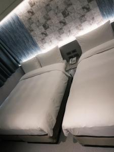 Rúm í herbergi á 新仕飯店-New City Hotel