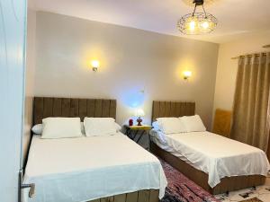 una camera da letto con due letti e un lampadario di Savor The king pyramids hotel a Il Cairo