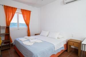 a bedroom with a bed with towels on it at Elea Villas Steni Vala Alonissos in Steni Vala Alonissos
