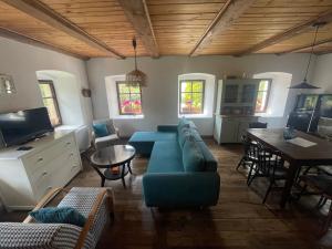 a living room with a blue couch and a table at Chalupa U Fílů in Lovečkovice