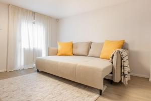a couch in a living room with yellow pillows at Seaside Loft Mano Jura 3 in Palanga