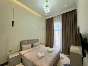 a bedroom with a bed with two towels on it at 3A, 183, 45m2, Tashkent City Park, Boulevard in Tashkent