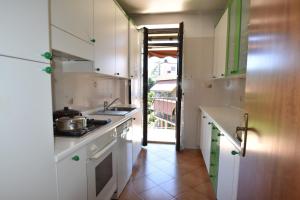 a kitchen with white cabinets and a sink and a doorway at Appartamento Isola Dei Fiori by Holidays LM in Luino +13 photos