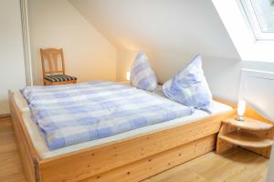 a bedroom with a bed with blue and white pillows at Bauerhof Kleingarn - Bauernhus 11 in Sulsdorf auf Fehmarn